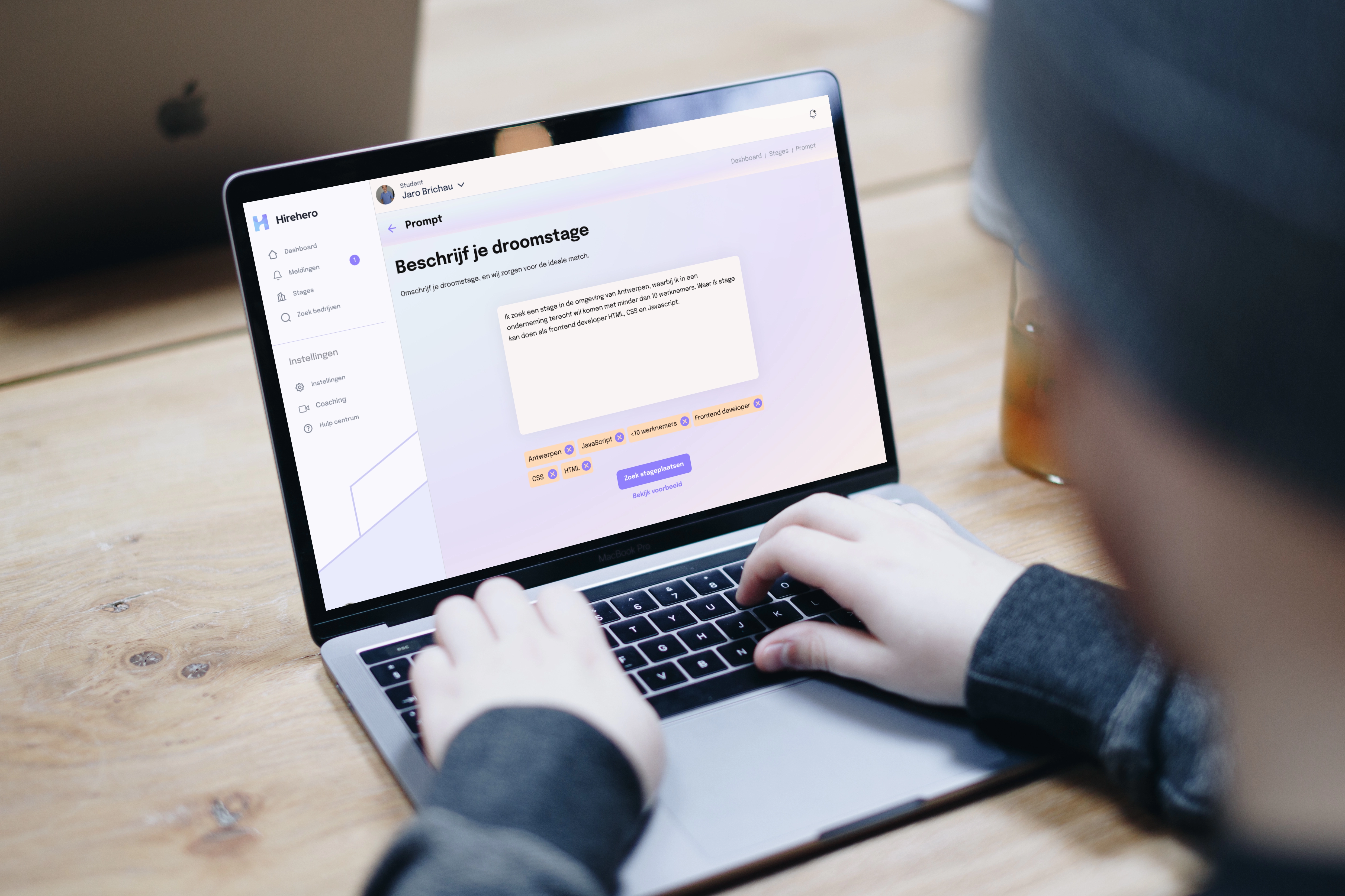 Persoon typt op een laptop met de Hirehero website open, waarbij een prompt wordt ingevuld om de droomstage te beschrijven, symboliserend de gebruiksvriendelijke en gepersonaliseerde stagezoekervaring die Hirehero biedt.
